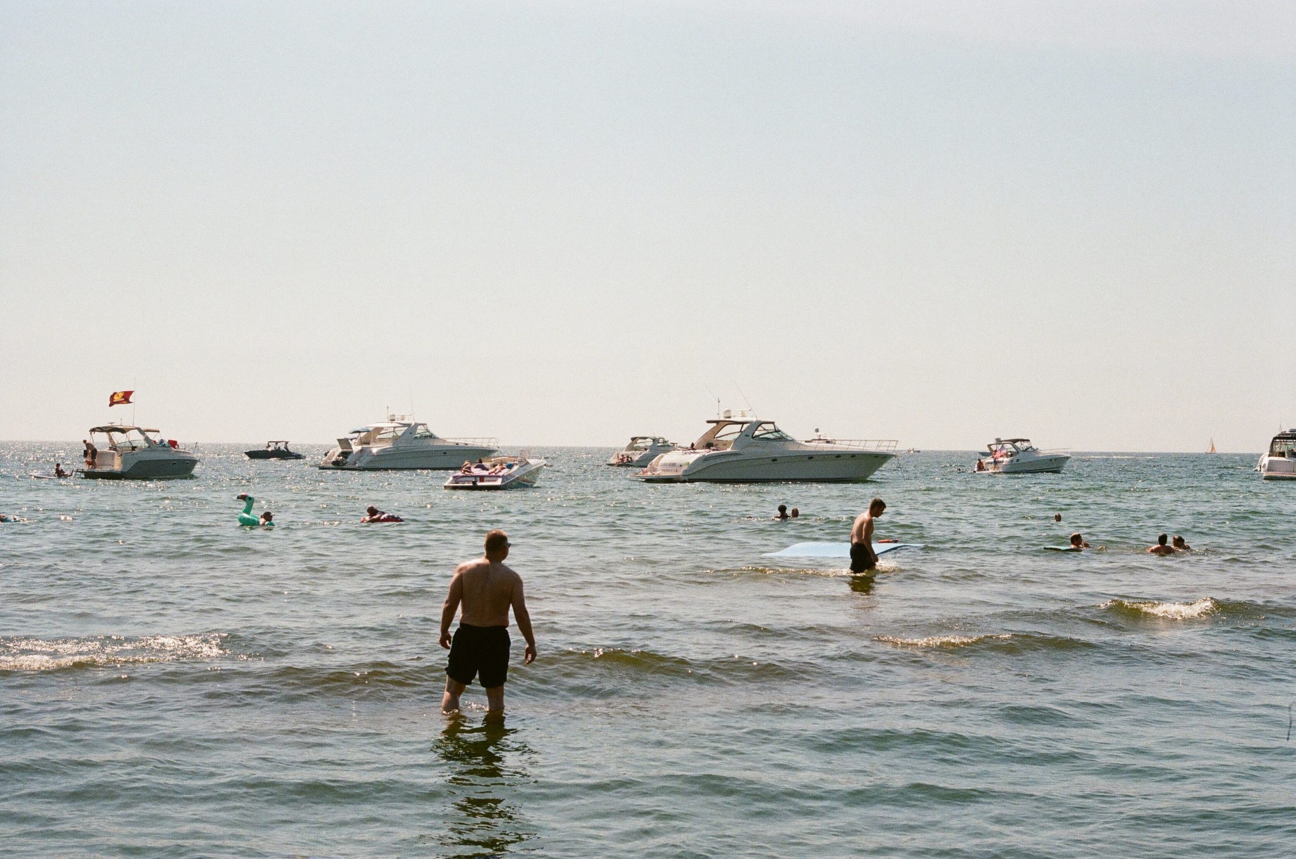 people in a kale with boats on the water